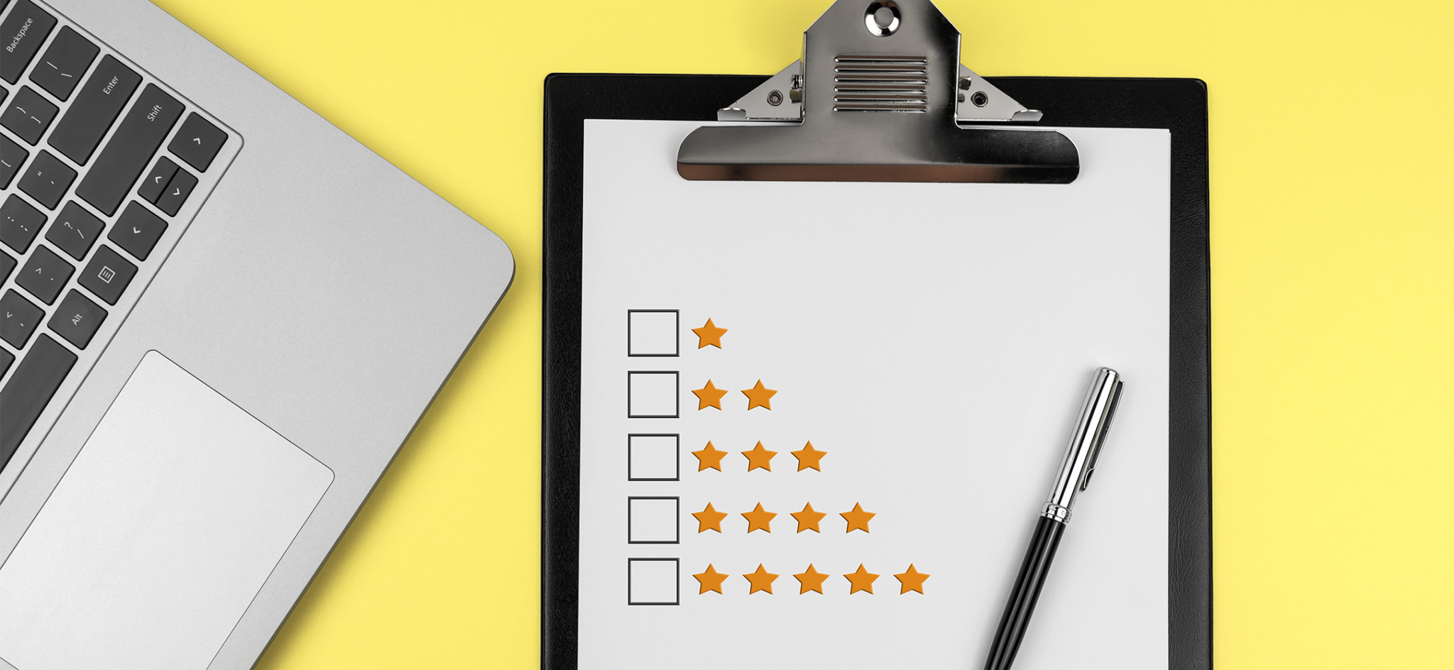 Laptop and clipboard with one to five star ratings representing an assessment